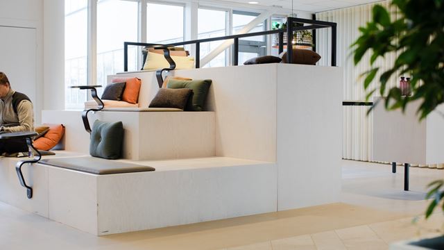 Loungeyta bland kontorshotellen med flera sittplatser och kuddar i färgglada färger
