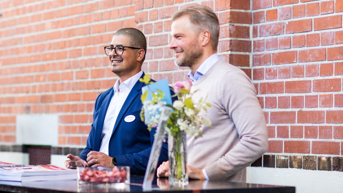 Två kollegor som står bredvid varandra på Wihlborgs årsstämma i Malmö