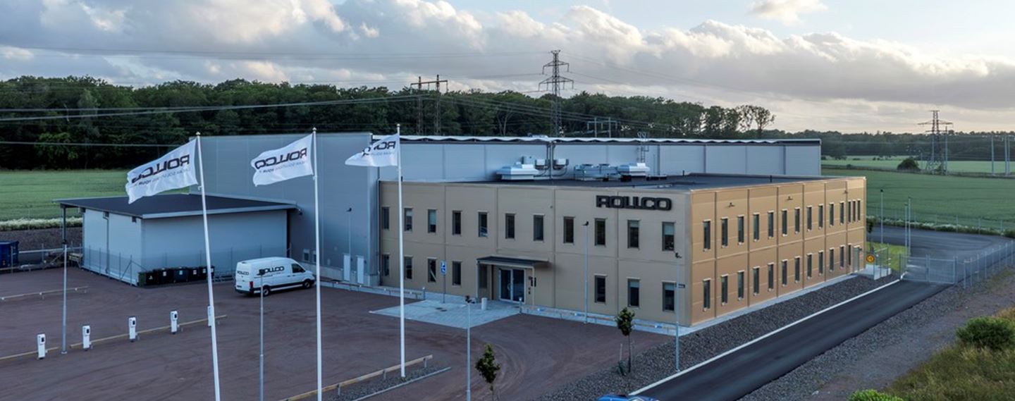 Den färdiga anläggningen. Rollco loggan på fasaden, solceller på taket och gräs utanför