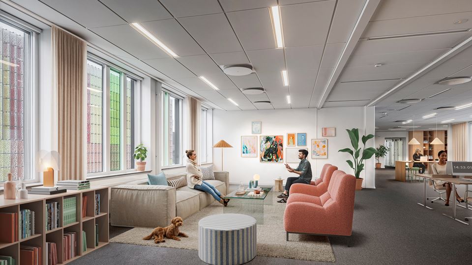 Kontorshuset Origo i Hyllie har snedtak och balkonger på varje våningsplan. En kvinna sitter på en kontorsstol intill snedtaket.