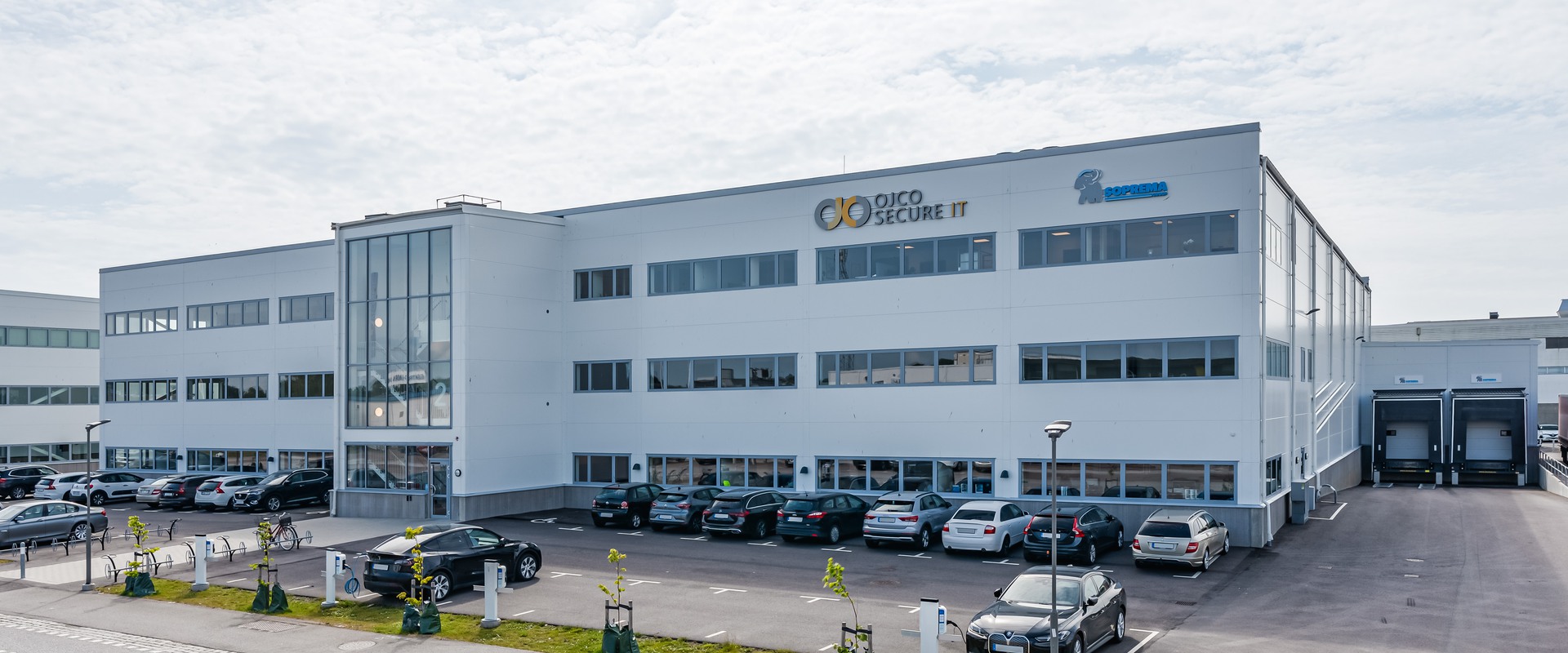 Trevåningshus med vit fasad.