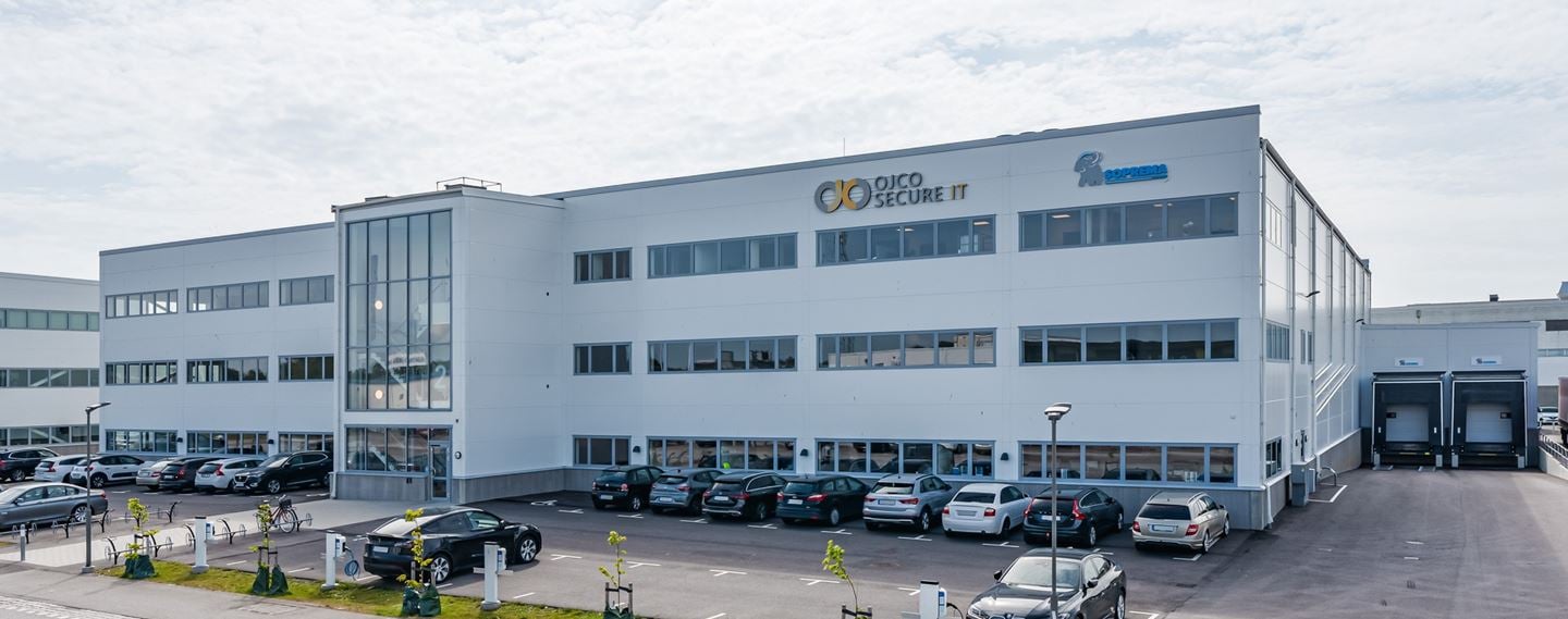 Trevåningshus med vit fasad.