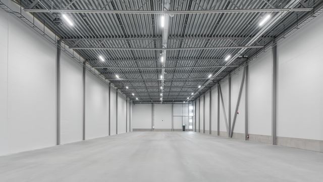 Bilden visar insidan av den ljusa färdigställda lokalen. Ett stort lagerrum med högt i tak