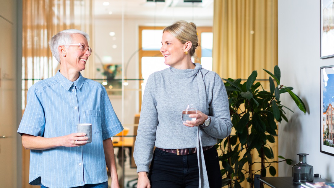 Två kvinnor som går genom kontorskorridor