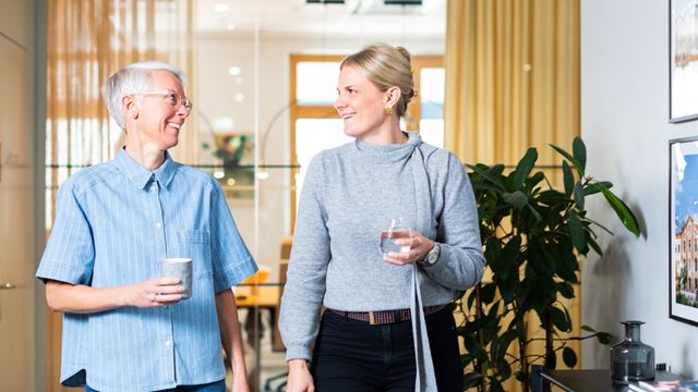 Två kvinnor som går genom kontorskorridor