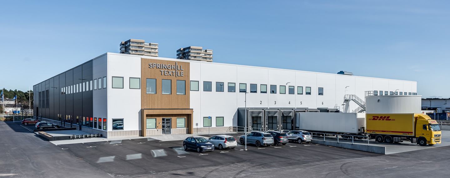 Flygfoto av lagerlokal med parkering runt om.