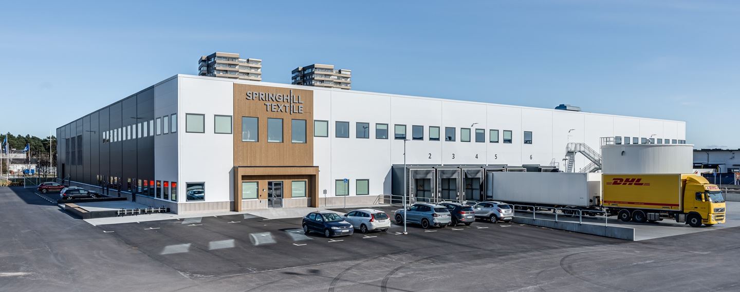 Flygfoto av lagerlokal med parkering runt om.