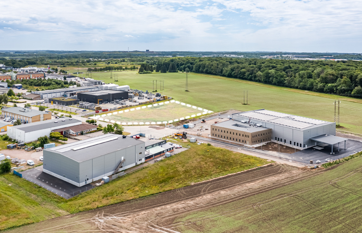 Flygvy över en produktionsanläggning i grått med stora körytor, Snårskogen 5 i Helsingborg.