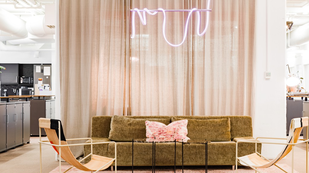 Avslappnad miljö i Fabriken1891, en grön soffa och fotöljer samt ett kök som syns i bakgrunden. 