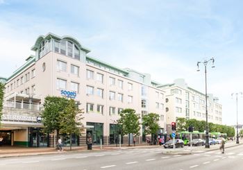 Vit fastighet med inglasade ytor vid entrén, Terminalen 3 i Helsingborg.