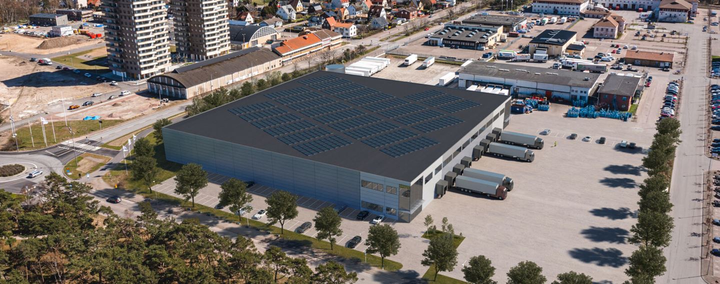 Flygfoto av lagerlokal med parkering runt om.