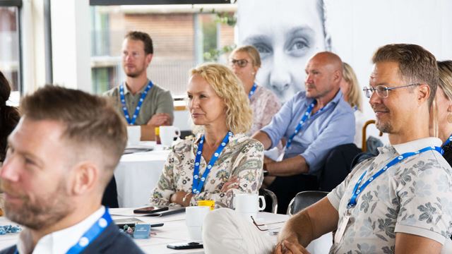 Personer i sommarkläder lyssnar på kapitalmarknadsdagarna i Båstad.