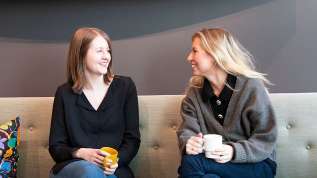 Praktikanterna Felicia och Malin sitter i soffan på Wihlborgs kontor.