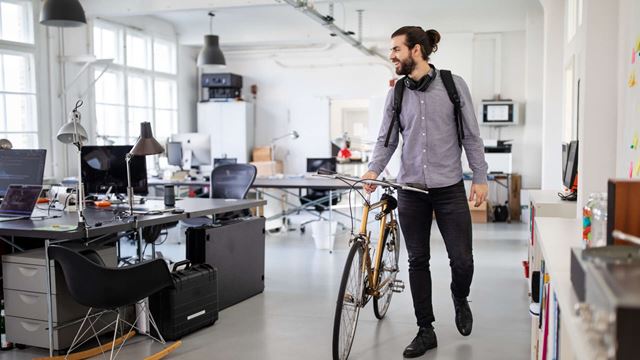 Man med cykel inne på kontoret.