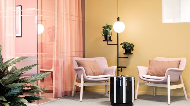 Två rosa fåtöljer i en hörna.