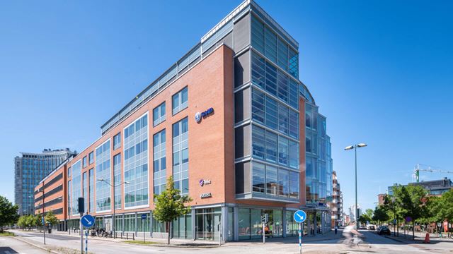 Skrovet 6, en fastighet i Dockan, Malmö med rött tegel och stora glaspartier.