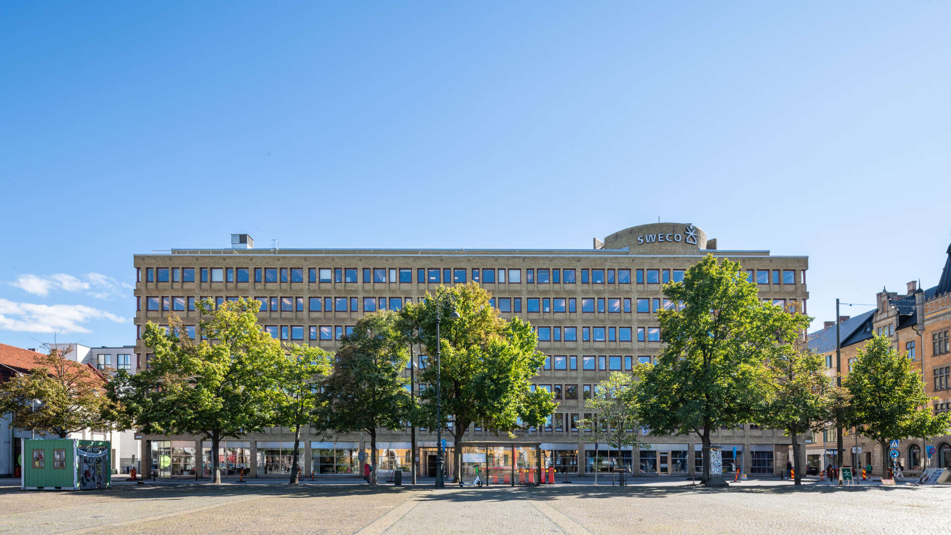Gul kontorsfastighet, Österport 7, med Drottningtorget i förgrunden.