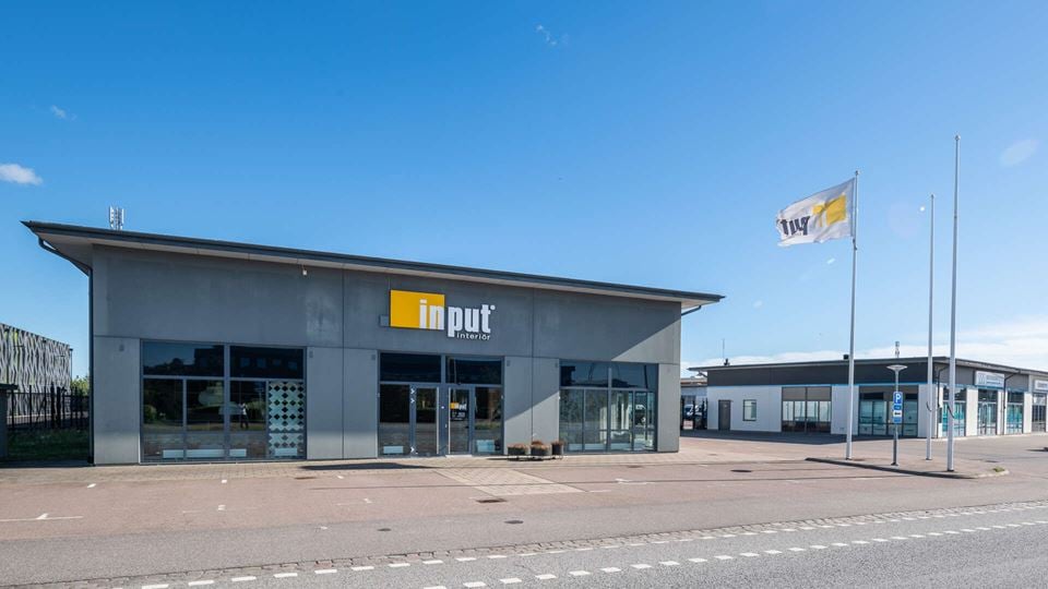 Fastighet för butik och industri med stora glaspartier på framsidan.