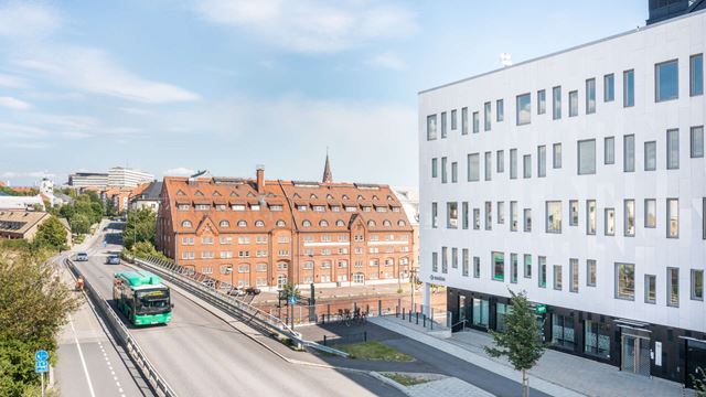 Vit modern kontorsfastighet vid järnvägen i Lund.