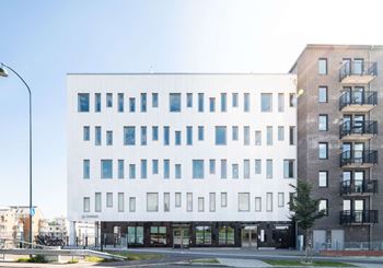 Vit och grå modern kontorsbyggnad i flera plan, Raffinaderiet 5 (Sockerbiten), fastighet med moderna kontorslokaler på Kung Oskars väg 11 vid Lund C.