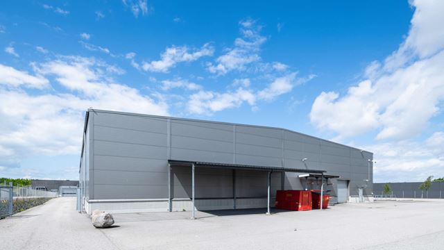 Lastytor under tak vid en grå industribyggnad, Olsgård 8 i Malmö.