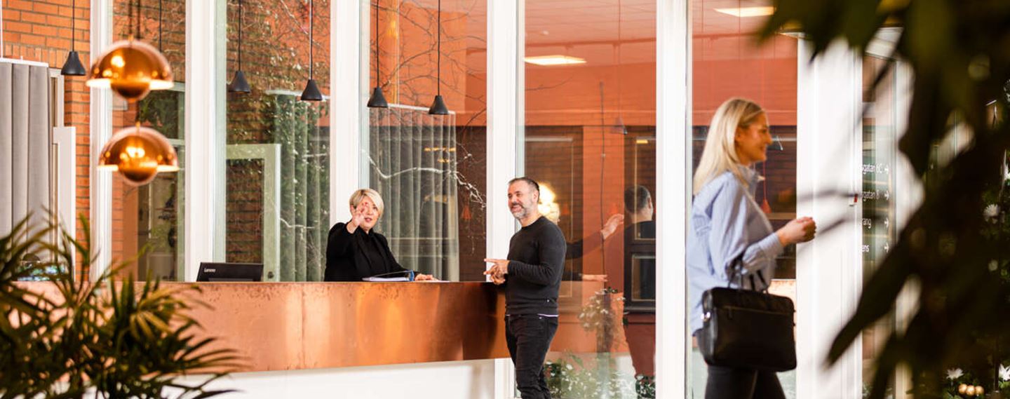 Välkomnande reception med soffor och växter i Boplatsen 3.